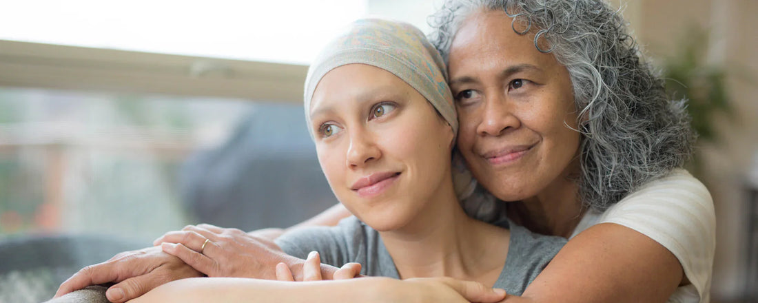 Woman suffering from cancer receiving a hug from her mother