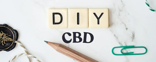 'DIY CBD' dice blocks resting on a table with a pencil, paperclip and a tag