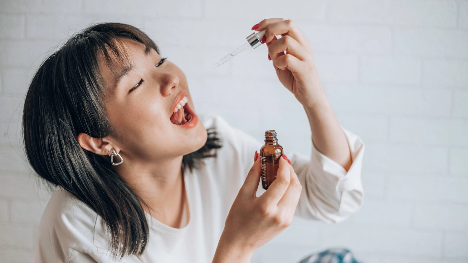 Woman taking CBD oil drops orally
