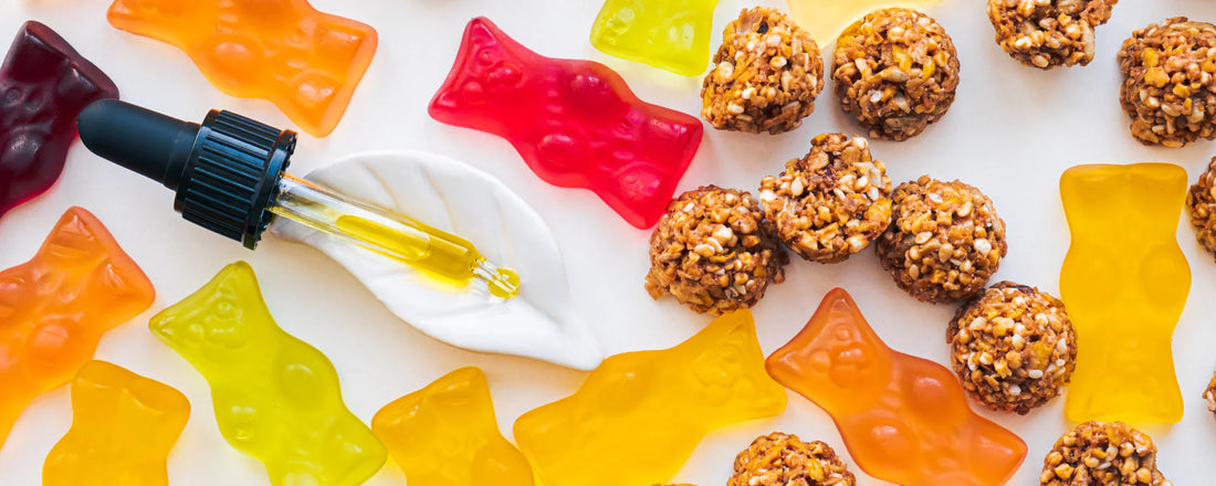 CBD oil dropper with a variety of CBD-infused edibles including oat balls and gummy bears