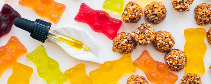 CBD oil dropper with a variety of CBD-infused edibles including oat balls and gummy bears