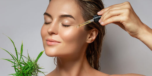 Someone applying CBD skincare oil to her face
