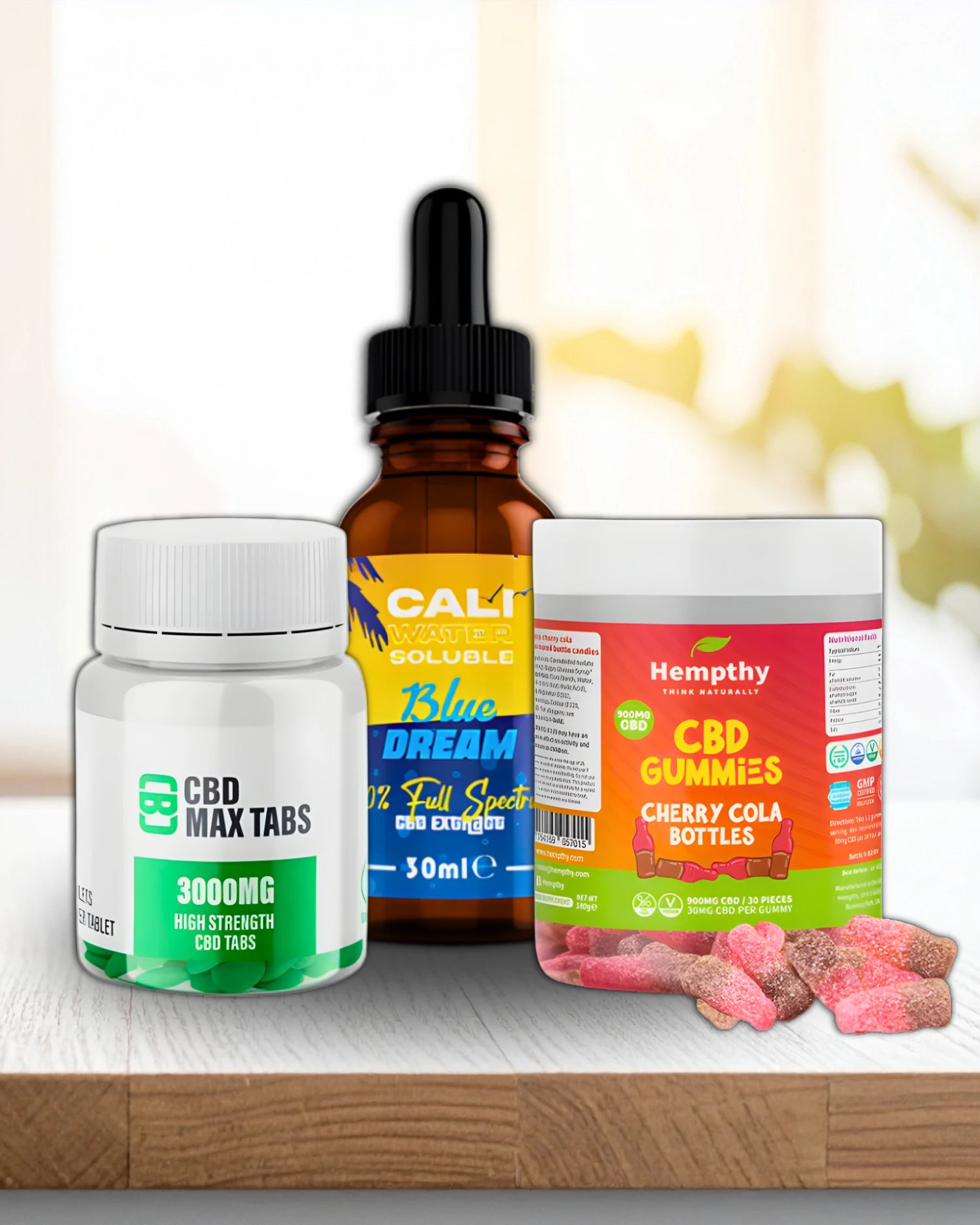 Three CBD products including a bottle, a dropper, and gummies on a wooden surface.