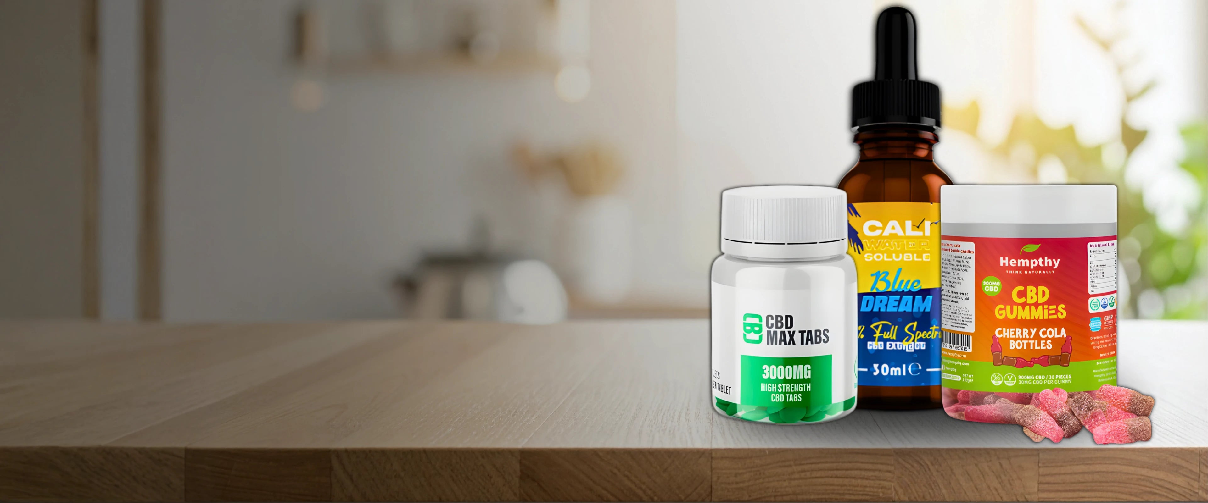 Three bottles of CBD products on a wooden table with a blurred background