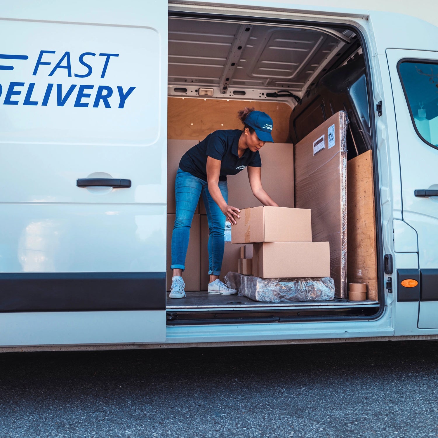 Person loading boxes into a van with 'Fast Delivery' branding.