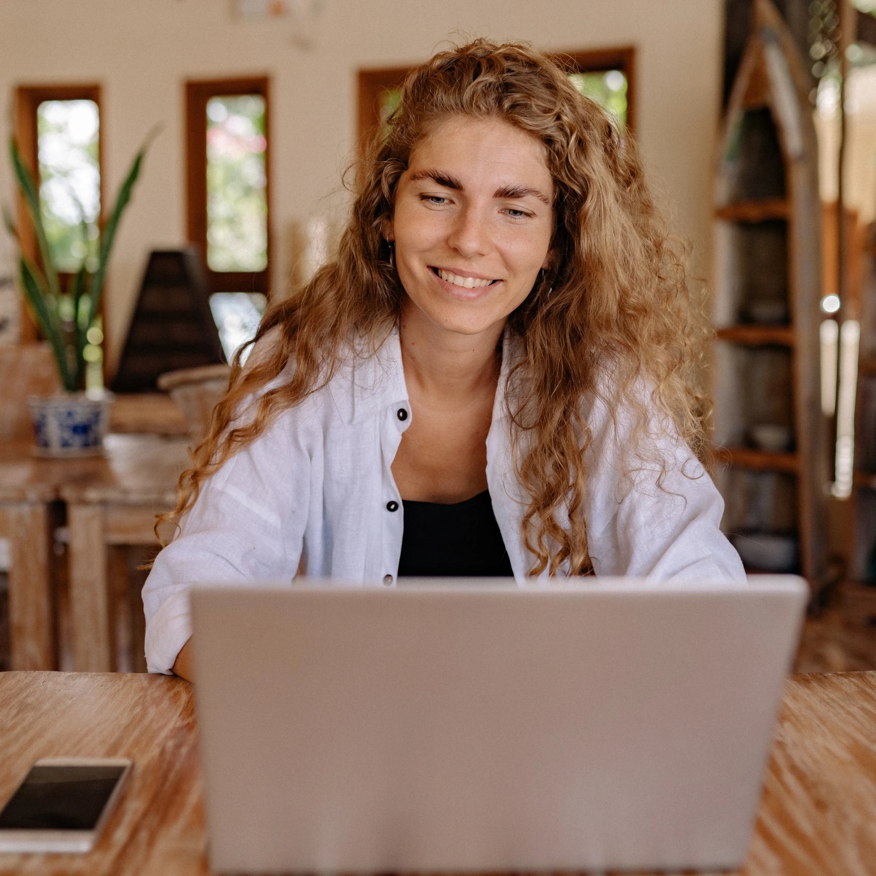 Woman at home writing an article on her laptop