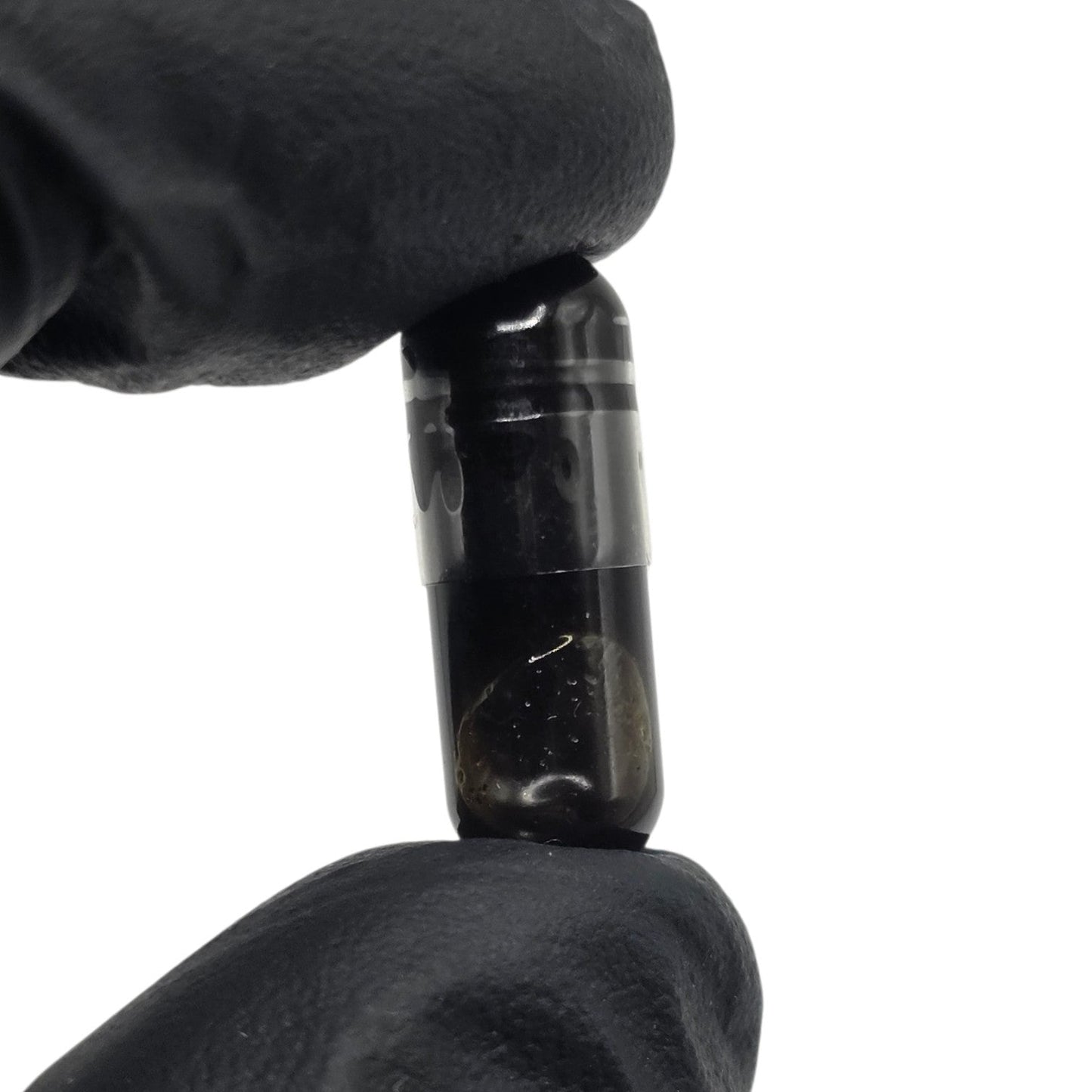 Single Improved Health Jack Frost CBG FECO capsule held in gloved fingers